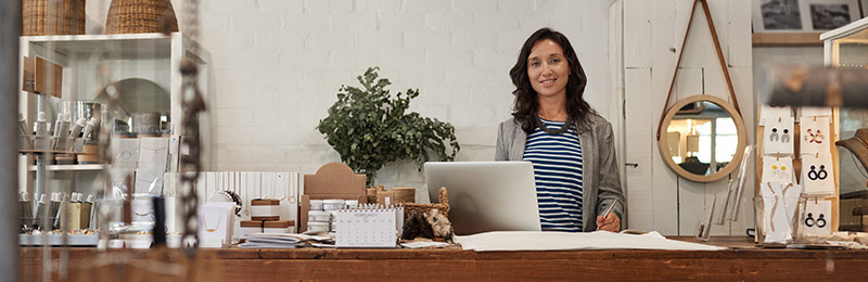 Female entrepreneur sitting in her home office working on a business plan for her SaaS business.